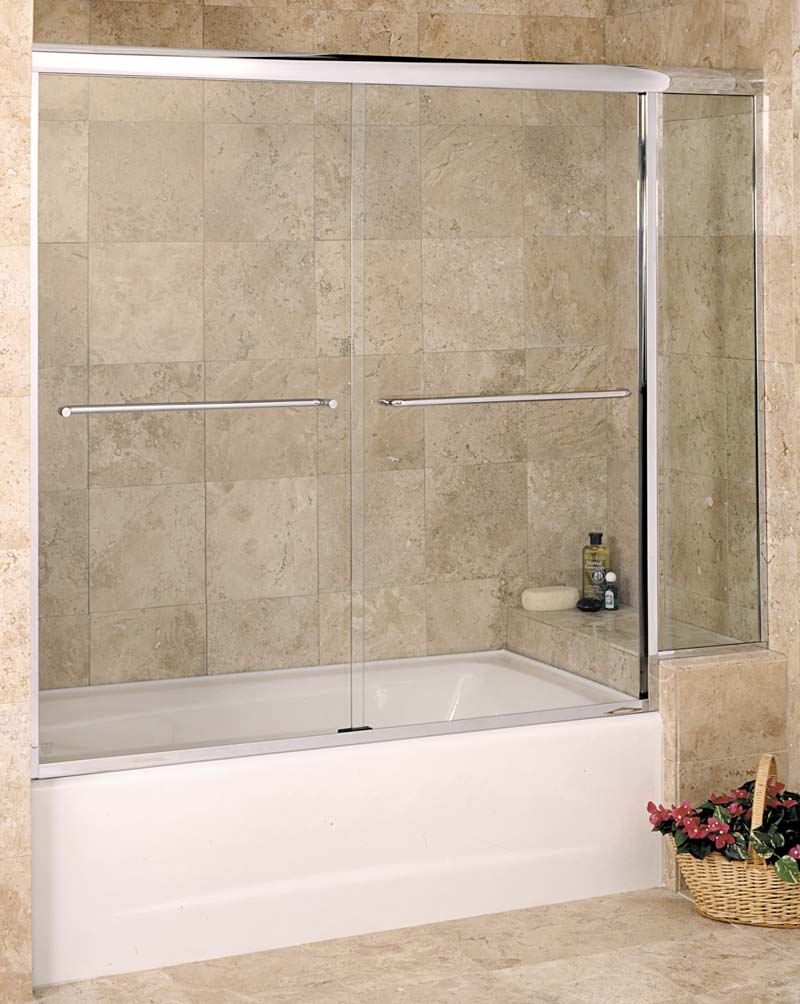 Frameless brass tub enclosure with towel handles and thick header. Toiletries visible through door.