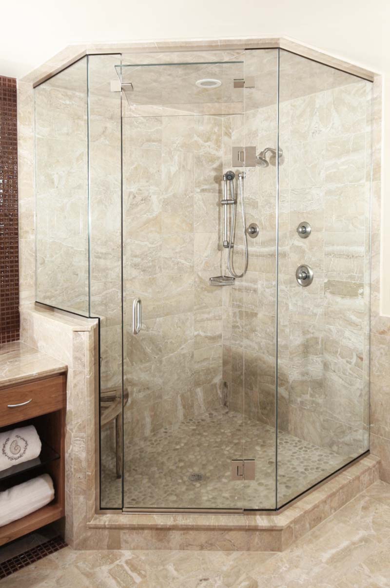 A fully-sealed, frameless glass steam shower enclosure with a slightly-open hinged transom vent above the door.