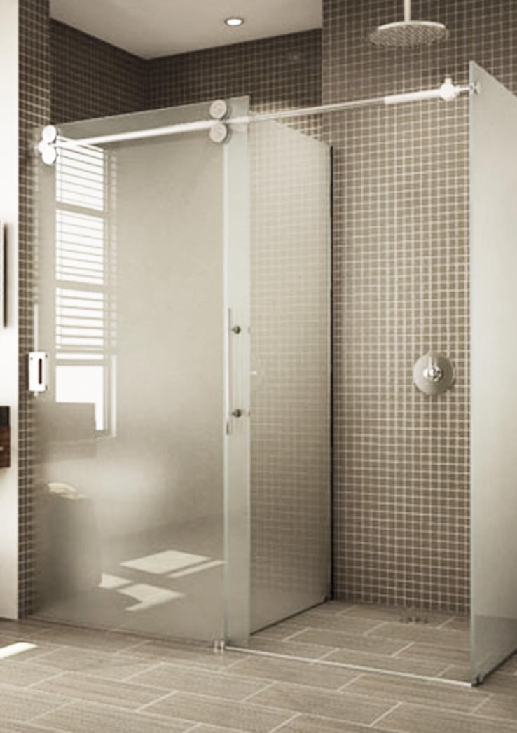 T-shaped glass enclosure with acid-etched glass. Sliding door is closed over toilet stall with shower stall visible.